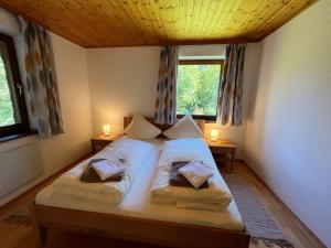 a bedroom with a bed with two pillows and two windows at Holiday Home Haus Sigfried by Interhome in Bischofshofen