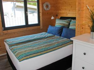 Una cama con una manta a rayas en una habitación en Holiday Home Ferienhaus Sarahlita by Interhome en Enspel