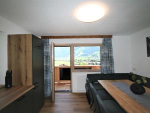 a living room with a table and a large window at Apartment Geislerhof-1 by Interhome in Ramsau