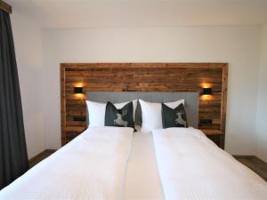 a bedroom with a white bed with black and white pillows at Apartment Heimatblick by Interhome in Ramsau
