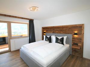 a bedroom with a large white bed and a window at Apartment Geislerhof-1 by Interhome in Ramsau