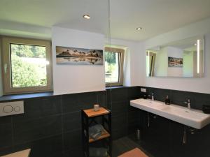 a bathroom with two sinks and a mirror at Apartment Heimatblick by Interhome in Ramsau
