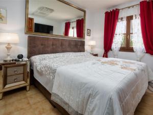 ein Schlafzimmer mit einem großen Bett und einem Spiegel in der Unterkunft Holiday Home Villa Jolanda by Interhome in Denia