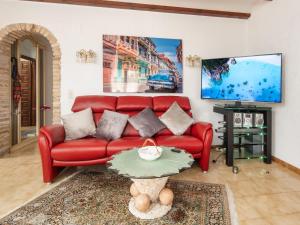 eine rote Couch in einem Wohnzimmer mit einem Tisch in der Unterkunft Holiday Home Villa Jolanda by Interhome in Denia + 27 Fotos