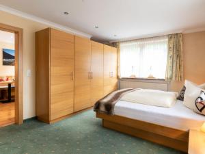 - une chambre avec un grand lit et des placards en bois dans l'établissement Apartment Gams by Interhome, à See
