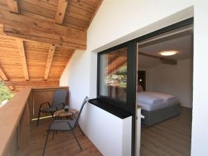 a room with a balcony with a bed and a window at Apartment Panoramablick by Interhome in Ramsau