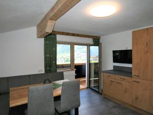 a dining room with a table and a television at Apartment Panoramablick by Interhome in Ramsau