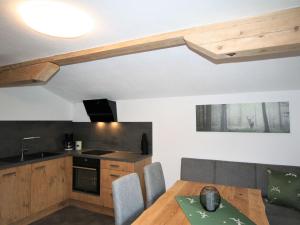 a kitchen with a wooden table with chairs and a sink at Apartment Panoramablick by Interhome in Ramsau