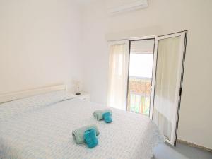 Un dormitorio blanco con una cama con toallas. en Holiday Home Rainbow by Interhome en Benidorm