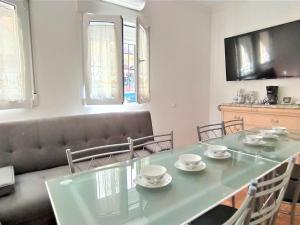 a dining room with a green table and a couch at Holiday Home Rainbow by Interhome in Benidorm