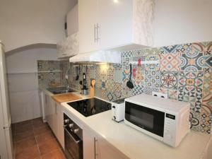 cocina con microondas blanco y azulejos en la pared en Holiday Home Rainbow by Interhome en Benidorm