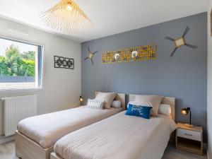 two beds in a room with white walls and a window at Holiday Home Palet Breton by Interhome in Locquirec