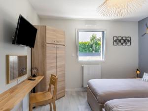 a bedroom with a desk and a bed and a tv at Holiday Home Palet Breton by Interhome in Locquirec