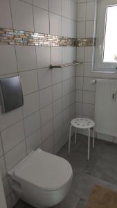a bathroom with a toilet and a small table at Haus Emmerblick in Schieder-Schwalenberg