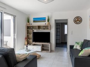 a living room with a couch and a television at Holiday Home Palet Breton by Interhome in Locquirec +25 photos