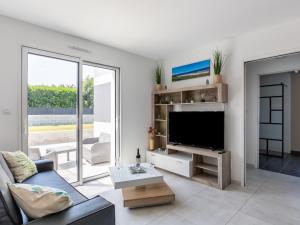 a living room with a large tv and a couch at Holiday Home Palet Breton by Interhome in Locquirec