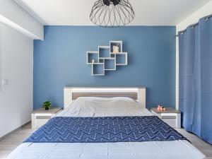 a blue bedroom with a bed and a blue wall at Apartment Le Phenicia by Interhome in Saint-Laurent-du-Var