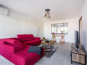 a living room with a red couch and a tv at Apartment Le Phenicia by Interhome in Saint-Laurent-du-Var