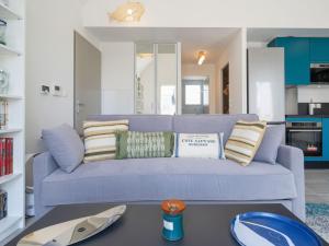 Sofá azul en la sala de estar con mesa en Apartment Le Clos Moguer-1 by Interhome, en Quiberon