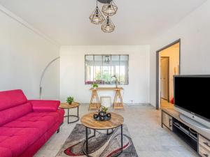 a living room with a red couch and a tv at Apartment Le Phenicia by Interhome in Saint-Laurent-du-Var +20 photos