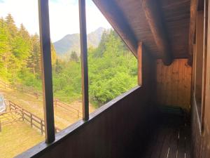 een raam in een hut met uitzicht op de bergen bij Chalet Sally by Interhome in Ledro
