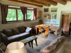 een woonkamer met een bank en een tafel bij Chalet Sally by Interhome in Ledro