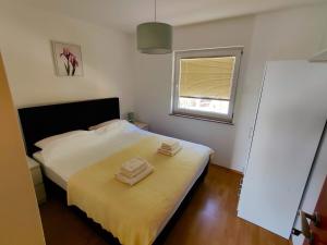 a bedroom with a bed with two towels on it at Apartments Lumar in Palit +24 photos