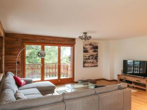 ein Wohnzimmer mit einem Sofa und einem TV in der Unterkunft Apartment Coeur des Alpes 301 by Interhome in Nendaz