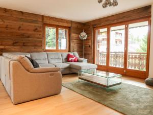 ein Wohnzimmer mit einem Sofa und einem Couchtisch aus Glas in der Unterkunft Apartment Coeur des Alpes 301 by Interhome in Nendaz