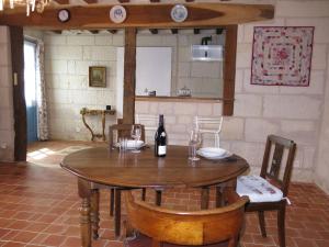 ein Holztisch mit einer Flasche Wein darauf in der Unterkunft Holiday Home Les Landes du Chinonais by Interhome in Huismes