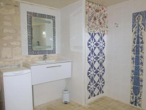 ein Bad mit einem Waschbecken und einem Spiegel in der Unterkunft Holiday Home Les Landes du Chinonais by Interhome in Huismes