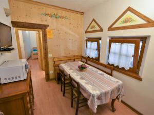 ein Esszimmer mit einem Tisch und einer Mikrowelle in der Unterkunft Apartment La Cá Vegia-1 by Interhome in San Cassiano