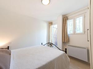 キャヴァレール・シュル・メールにあるApartment L'Eau Blanche by Interhomeの白いベッドルーム(ベッド1台、窓2つ付)