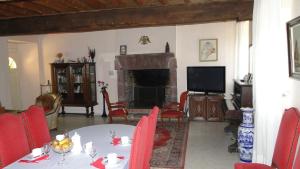 a living room with a table and a fireplace at Manoir La Haie Chapeau in Saint-Thurial