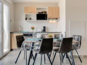 a kitchen and dining room with a glass table and chairs at Apartment Soleil Couchant B03 by Interhome in Mimizan