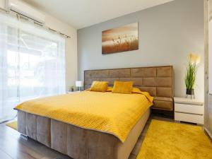 a bedroom with a large bed with a yellow bedspread at Apartment Juventus by Interhome in Balatonföldvár