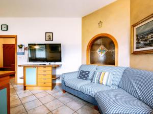 a living room with a blue couch and a flat screen tv at Apartment Ardoney by Interhome in Campitello