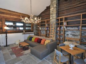 a living room with a couch and a chandelier at Chalet Baita Barin by Interhome in Madesimo