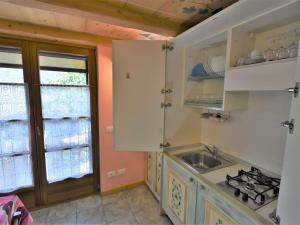 eine Küche mit weißen Schränken, einem Waschbecken und einem Fenster in der Unterkunft Apartment La Cá Vegia-2 by Interhome in San Cassiano