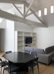 uma sala de estar com uma mesa e um sofá em Maison 80m2 entièrement rénovée à 1,5km de la plage des Conches em Longeville-sur-Mer