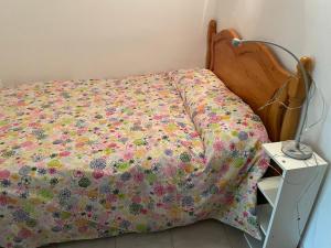 un letto con copriletto floreale e comodino. di Sol i Neu a Encamp