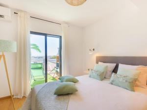 a bedroom with a large bed with a large window at Apartment Wave Dream by Interhome in Olhão +13 photos