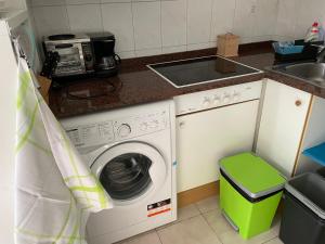 una cucina con lavatrice e lavandino di Sol i Neu a Encamp