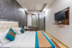 a bedroom with a large bed and a flat screen tv at DIPLOMAT REGENCY in New Delhi