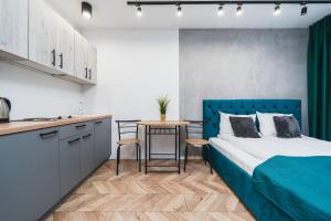 sypialnia z niebieskim łóżkiem i stołem w obiekcie Ice Apartments w Krakowie