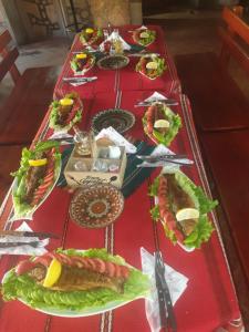 a table with sandwiches and other food on it at Къща за гости Динас in Zmeitsa