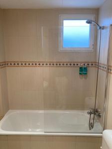 een badkamer met een bad en een raam bij Medinaceli airco, wifi and free parking in Valencia