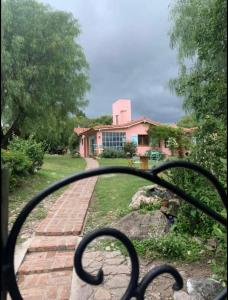 una vista de una casa desde detrás de una valla metálica en Amoroso Chalet con súper jardín en Los Cocos