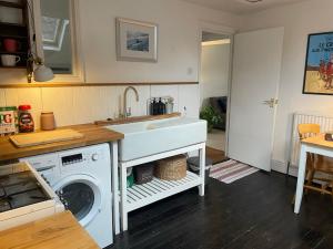 a kitchen with a sink and a washing machine at Cheltenham Road One Bedroom Apartment in Bristol