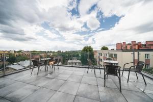 a patio with chairs and tables on a roof at Ice Apartments in Kraków